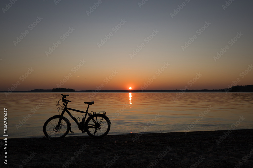 Fahrrad im Sonnenuntergang als Silhouette im Sonnenuntergang am Großen Plöner See Prinzeninsel