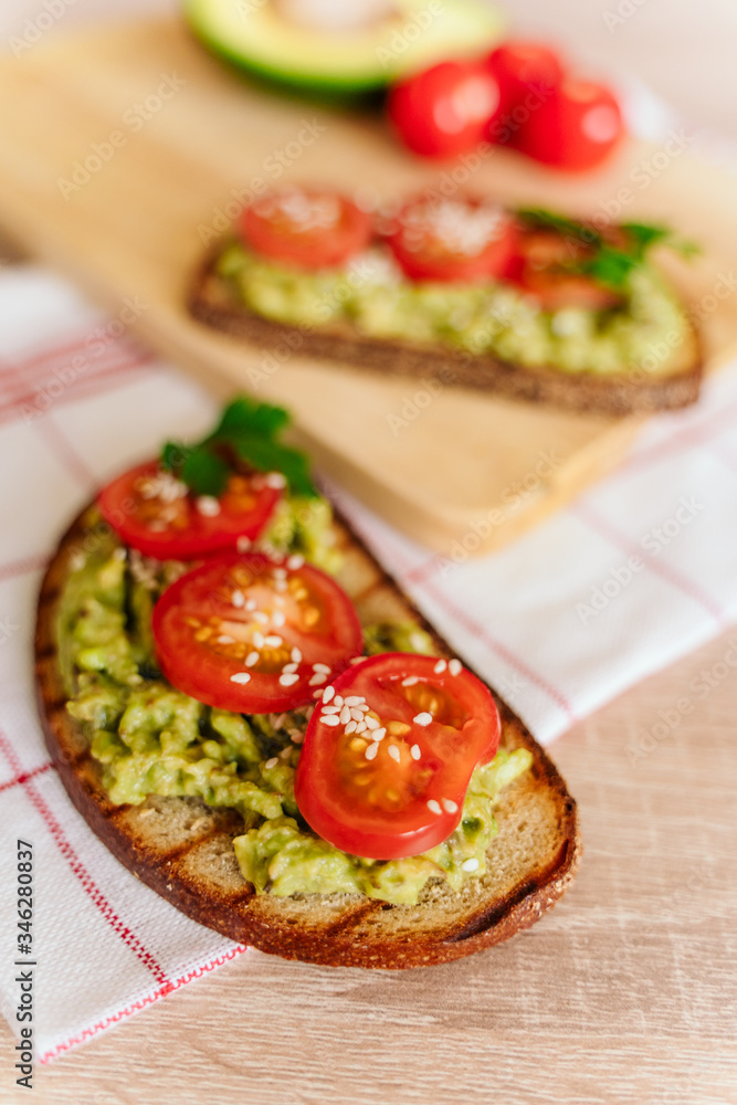 toasted bread with avocado paste and fresh tomato. Avocado mixed with lemon juice is spread on bread. health food concept, vegan, vegetarian toasted bread with avocado paste and fresh tomato. Avocado mixed with lemon juice is spread on bread. health food concept, vegan, vegetarian