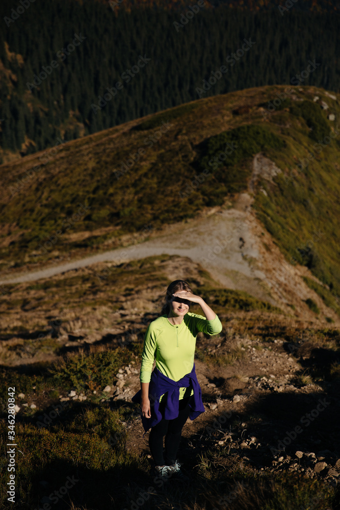 Female trail runner enjoys the view in mountains
