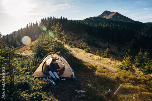 Woman hiker in tent in mountains