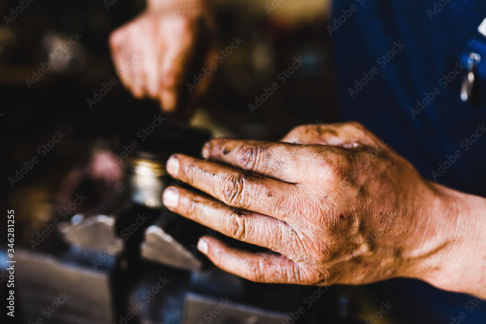 hands of a car mechanic in work with car parts