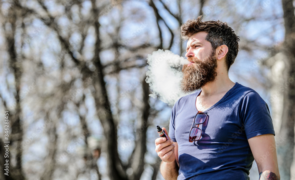 Stress relief concept. Bearded man smoking vape. White clouds of flavored smoke. Smoking electronic cigarette. Man long beard relaxed with smoking habit. Man with beard and mustache breathe out smoke Stress relief concept. Bearded man smoking vape. White clouds of flavored smoke. Smoking electronic cigarette. Man long beard relaxed with smoking habit. Man with beard and mustache breathe out smoke