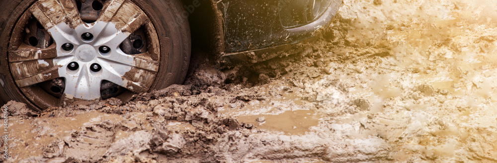 The car got stuck on a dirt road in the mud. Wheel of a car stuck in the mud on the road. The car got stuck on a dirt road in the mud. Wheel of a car stuck in the mud on the road.