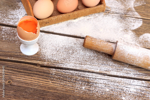 Background with flour and eggs on a wooden table