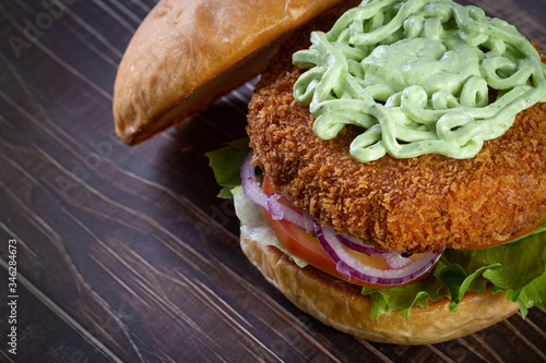 Chicken burger with lettuce, tomato, purpple onion and handmade mayo on the wood table. Delicious. photo