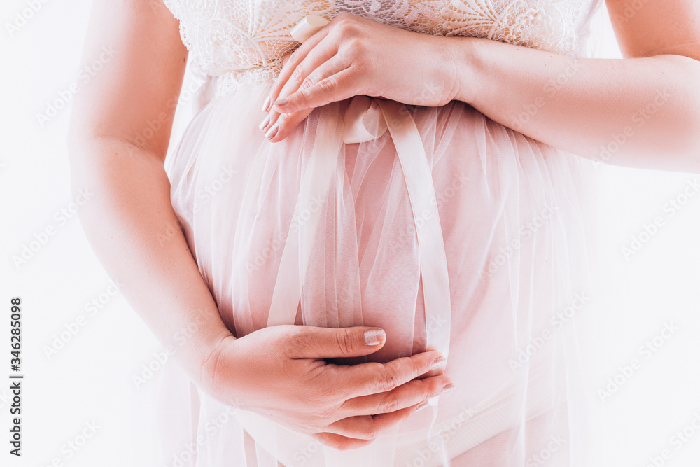 Naklejka premium Pregnant belly on a white background. Tender pregnancy.