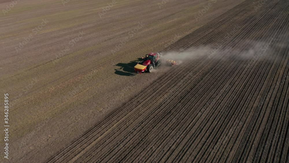 Aerial view of a moving tractor that plows and then sows the fields Aerial view of a moving tractor that plows and then sows the fields
