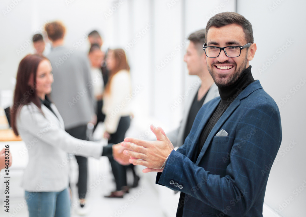 smiling business man standing in the hall of the business center smiling business man standing in the hall of the business center