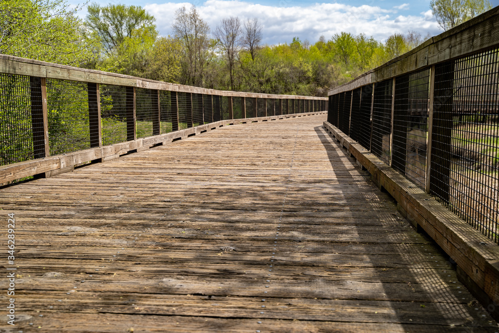 Low angle view of a pedestrain footbridge in Elm Creek Park Reserve along the trails on a spring day in Maple Grove Minnesota