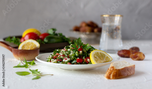 Tabbouleh salad with bread and fresh water with dates. Iftar, evening meal during month of Ramadan.