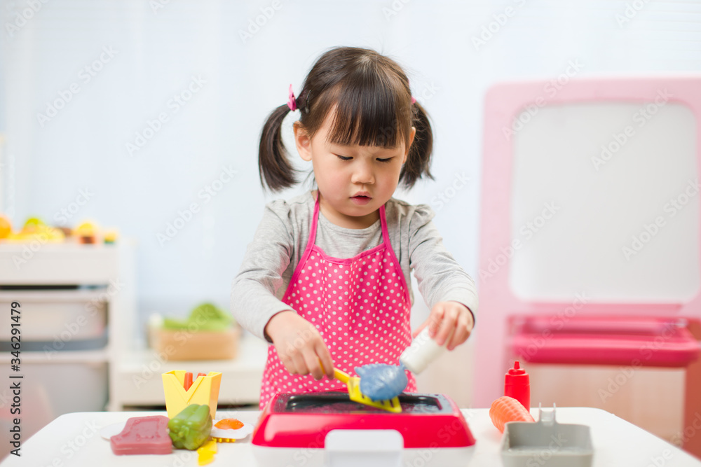 toddler girl pretend play food preparing role at home against white background toddler girl pretend play food preparing role at home against white background