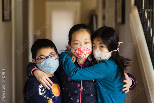 Portrait of Asian siblings wearing homemade masks in isolation