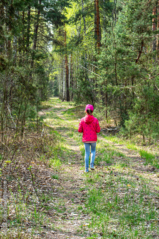 Girl in red jacket on forest path Girl in red jacket on forest path