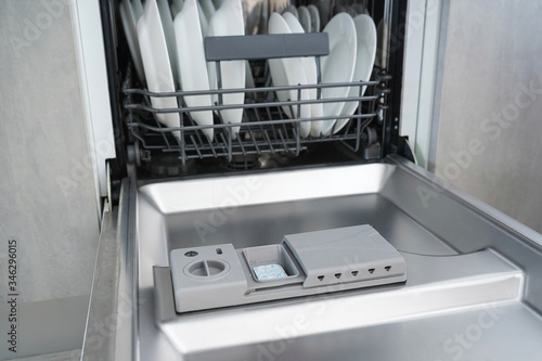 Open dishwasher with clean dishes. Close-up.