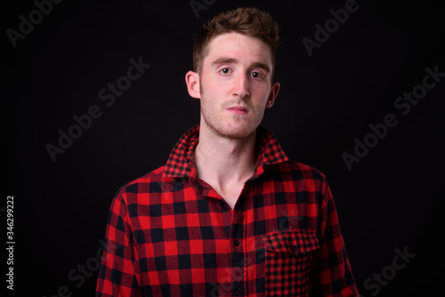 Face of young handsome hipster man looking at camera