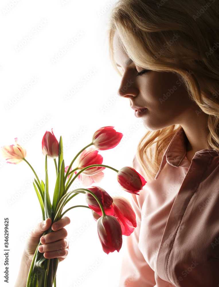Fototapeta premium Pretty woman with a bouquet of tulips.