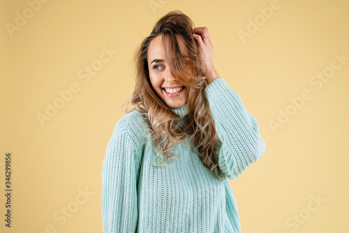 Beautiful standing woman model posing and smiling solated on a yellow background © Iryna