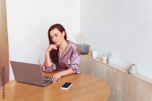 Affectionate woman working home looking on the laptop in the kitchen