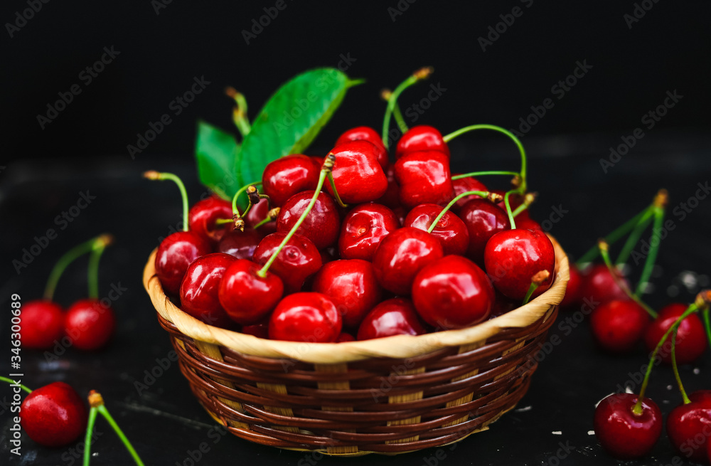 Fresh cherries placed in a basket and black cherries with water splashes. Fresh cherries placed in a basket and black cherries with water splashes.
