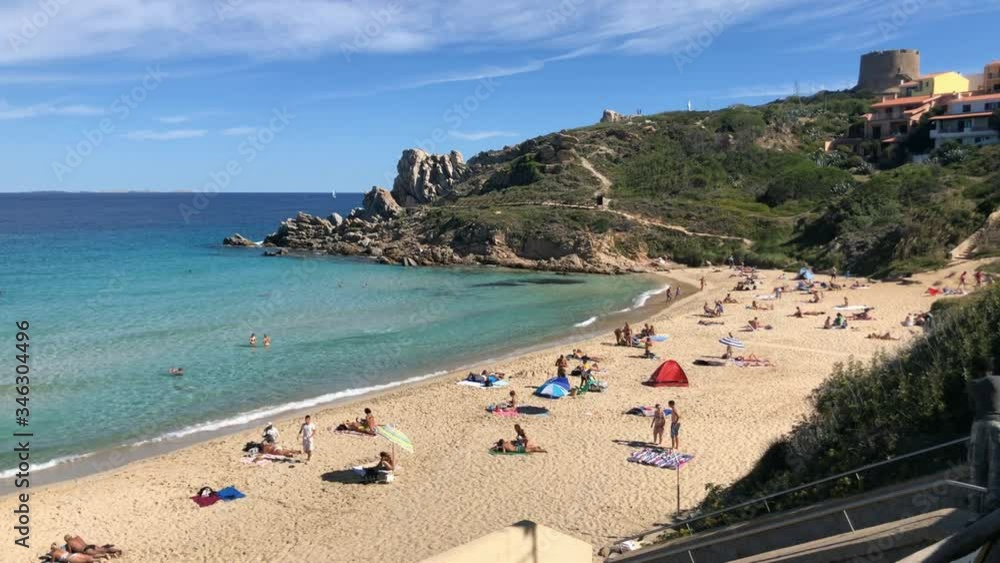 summer beach panorama with people taking sun in front of an emerald transparent sea summer beach panorama with people taking sun in front of an emerald transparent sea