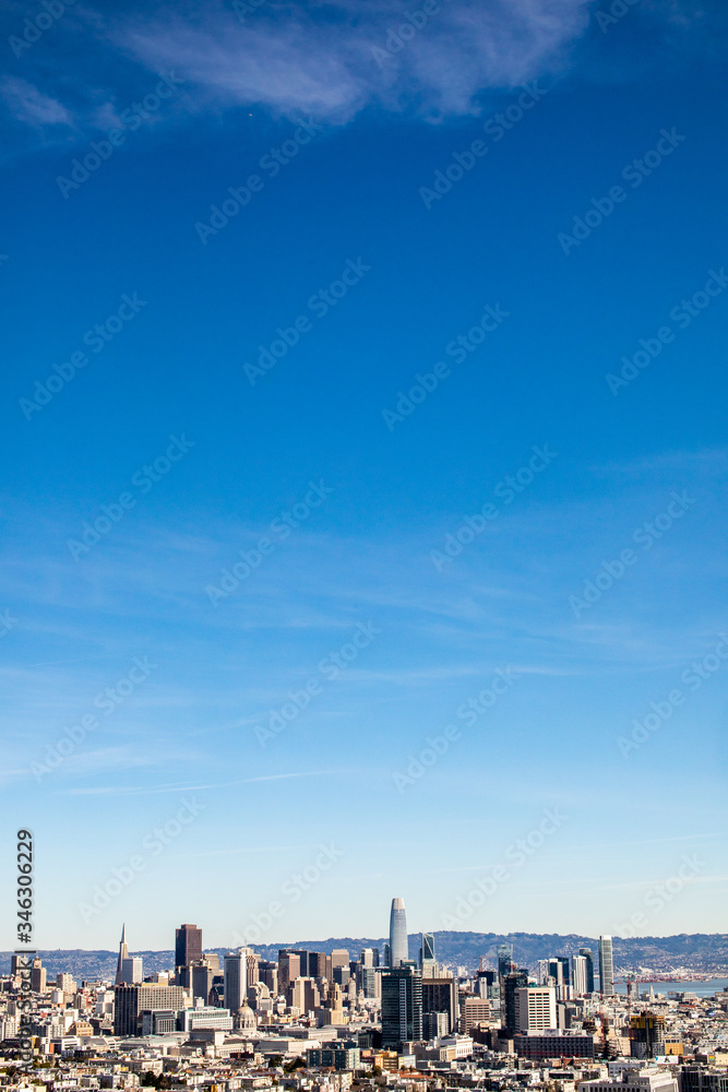 A cityscape of San Francisco with bright blue sky and clouds above it. A cityscape of San Francisco with bright blue sky and clouds above it.