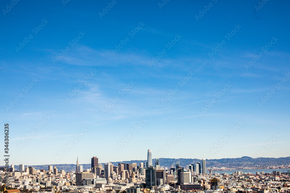 A cityscape of San Francisco with bright blue sky and clouds above it. A cityscape of San Francisco with bright blue sky and clouds above it.