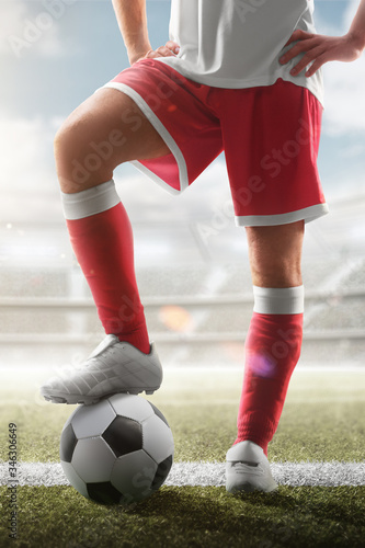 Soccer closeup. Leg of soccer player on the ball. Soccer background. Day stadium. Soccer vertical. Sport