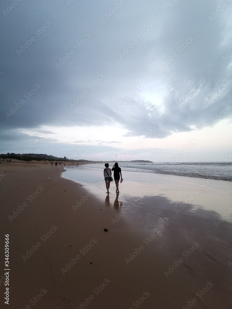 Reflection of two ladies on the Dee Why Beach, Sydney Australia Reflection of two ladies on the Dee Why Beach, Sydney Australia