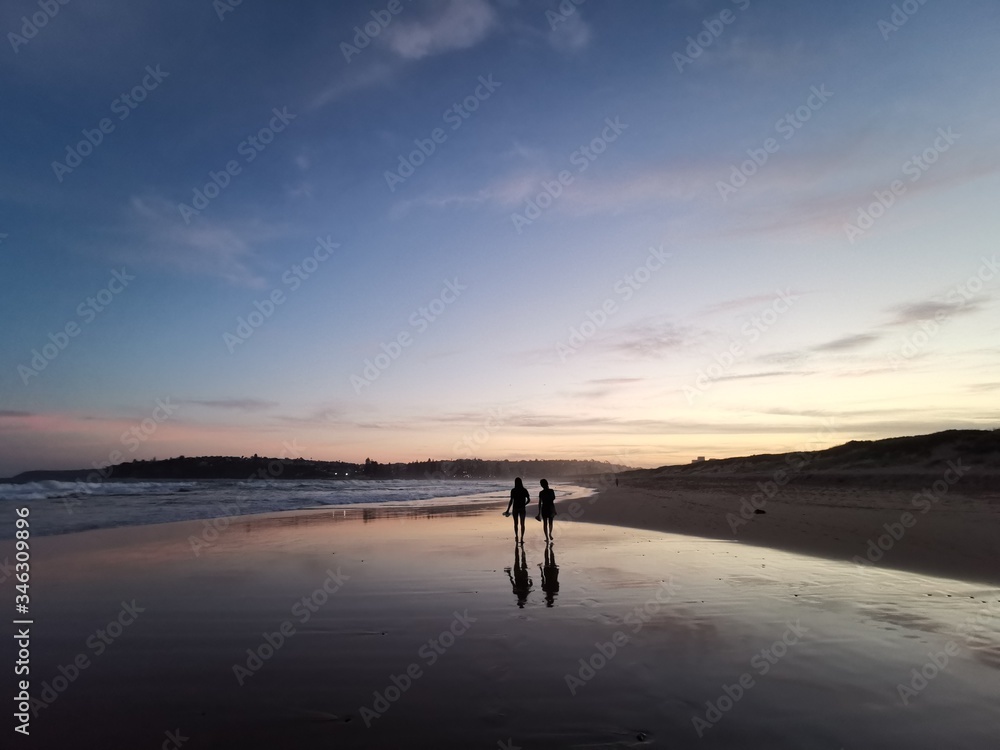Reflection of two ladies on the Dee Why Beach, Sydney Australia
