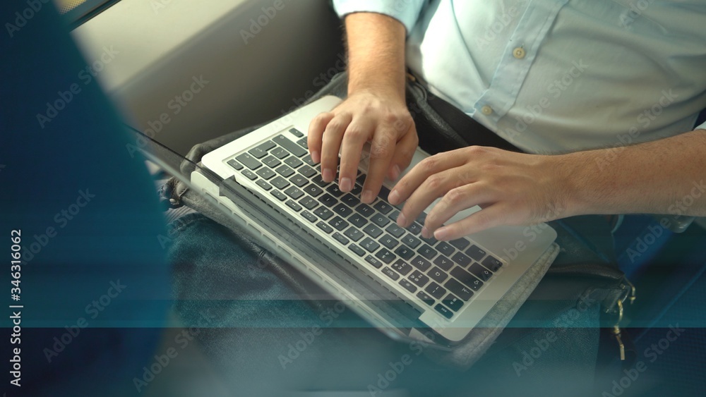 Top view of an unrecognizable businessman s hands using his laptop while he is riding a train