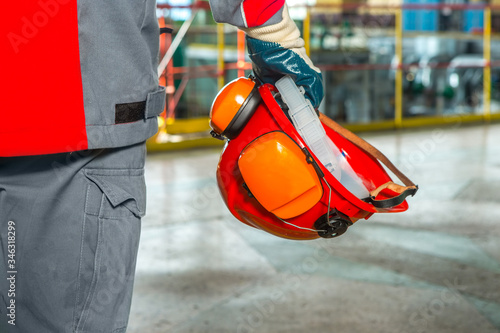 Photos A worker holds a helmet in his hands