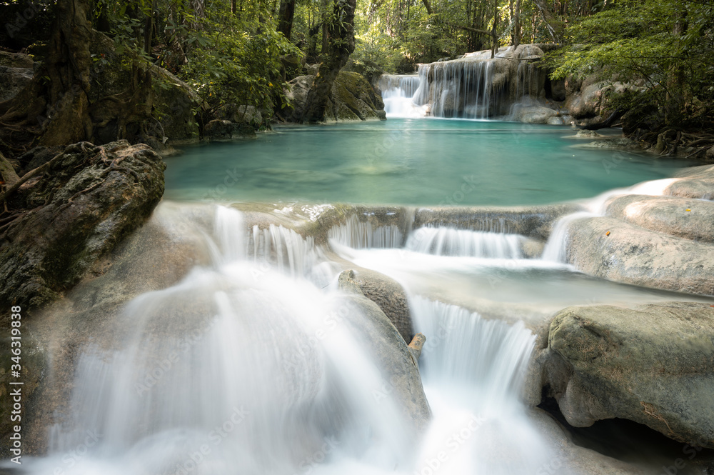 Fototapeta premium A beautiful waterfall deep in the tropical forest, steep mountain adventure in the rainforest.