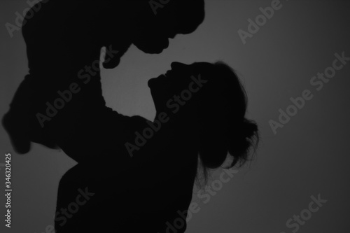 Silhouette Of Happy Mother and Baby. Mom smiling to baby, Happy Mother's Day concept