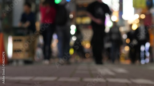 Blurred silhouettes of people at pedestrian alley, Ueno area in night time. Popular place for dinning and entertainment. Tokyo nightlife concept. Bright signs on background, low camera position