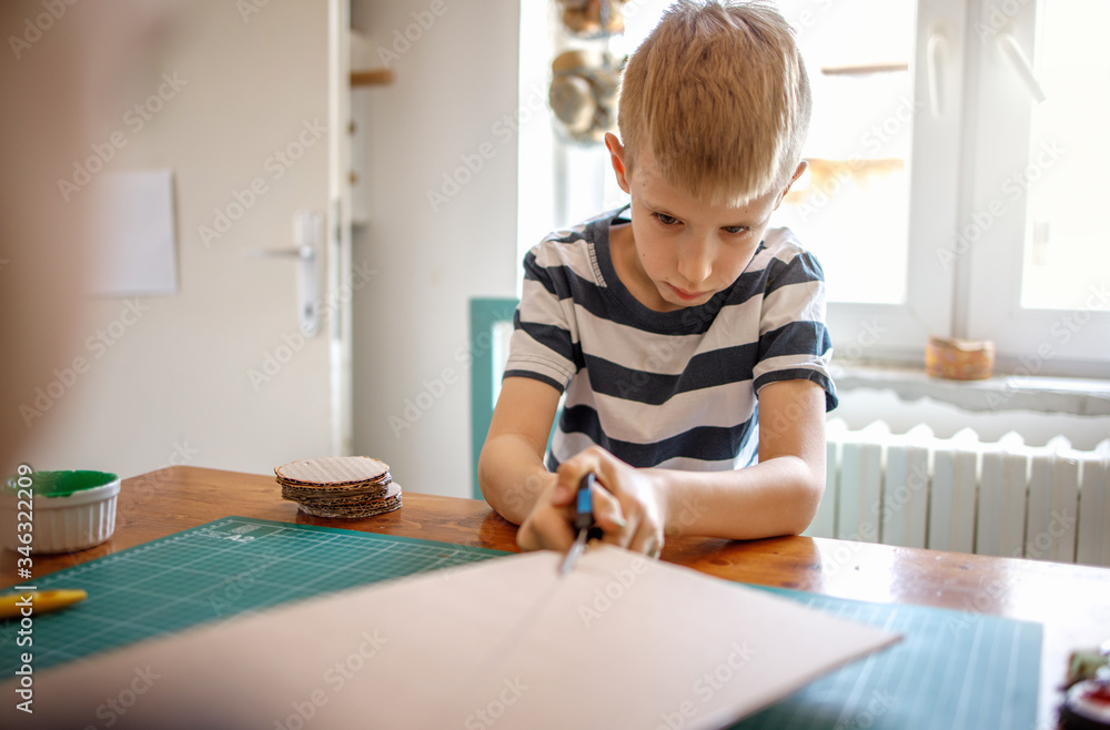 Little boy cutting cardboard, quarantine project
Little boy cutting cardboard, quarantine project