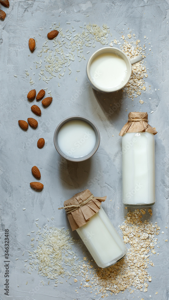 natural vegetable milk in bottles on a stone background, on top natural vegetable milk in bottles on a stone background, on top