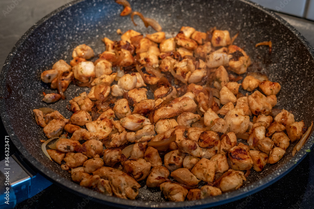 Pieces of chicken fried in a frying pan Pieces of chicken fried in a frying pan