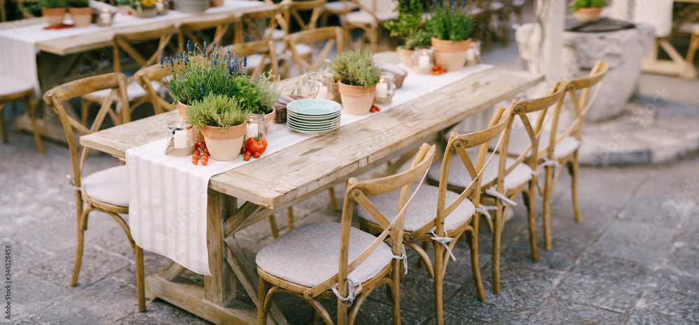 Prijem za stol za svadbenu večeru za zalaska sunca vani. Drevni pravokutni  drveni stolovi s trkačem krpama, drvene vintage stolice, posude s lavandom,  cherry rajčice i glinene posude s limunom na stolovima #