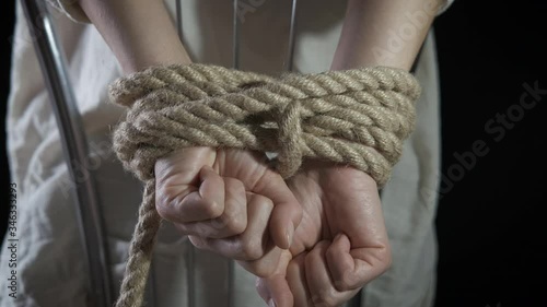 Hostage. The hands of the women are tied at the back. Trafficking in women concept. photo