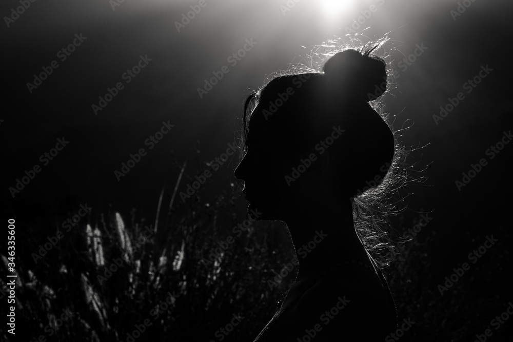 Silhouette of woman at sunset with the sun in the background
