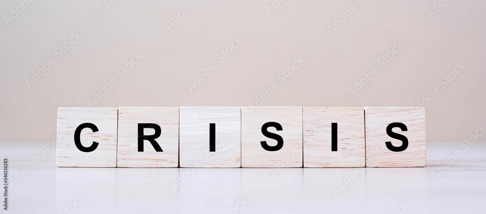 Obraz premium wooden cube blocks with CRISIS text on table background. Coronavirus pandemic, risk, fall Business, unemployment, Economic recession and Bankrupt concept