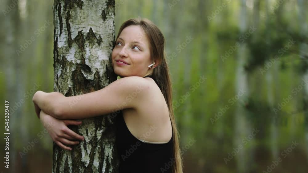 Young happy caucasian woman hugging the tree in the forest. Slow motion Young happy caucasian woman hugging the tree in the forest. Slow motion