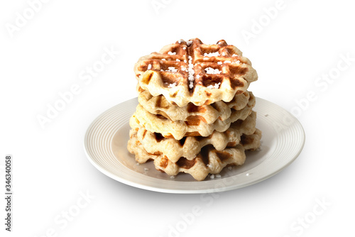 belgian waffle over a white plate with sugar