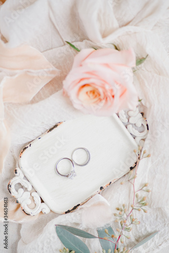wedding rings and rose on the table