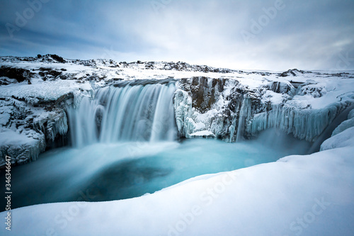 Frozen Hranabjargafoss waterfall during winter