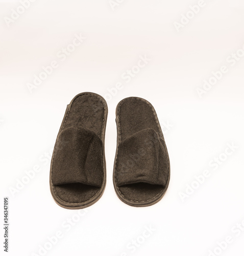Comfy plush hotel amenity slippers isolated against white background. 