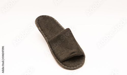 Comfy plush hotel amenity slippers isolated against white background. 