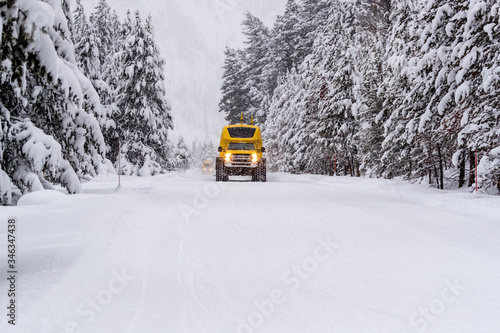 Heavy duty snow bus vehicle plows over snow of Highway 20 in Yellowstone in winter