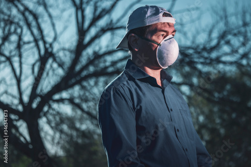 Middle-aged man dressed in blue shirt puzzled by coronavirus situation in parke looking thoughtful