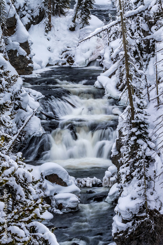 Keplar Cascades flow through snowy scenery in Yellowstone